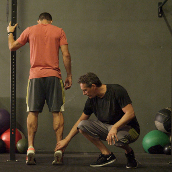 Scott Malin assessing an ankle with a client